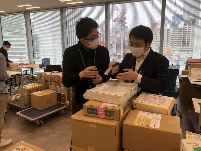 A Collaborative Center member shows another Suntory employee how to do a task during an event 